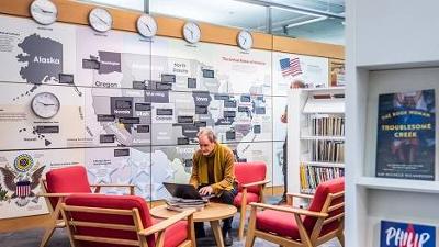 Man sitting at a table and using a laptop in the American Library