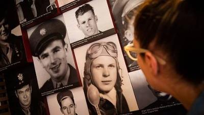 Man looking at images of servicemen in a display at the American Library